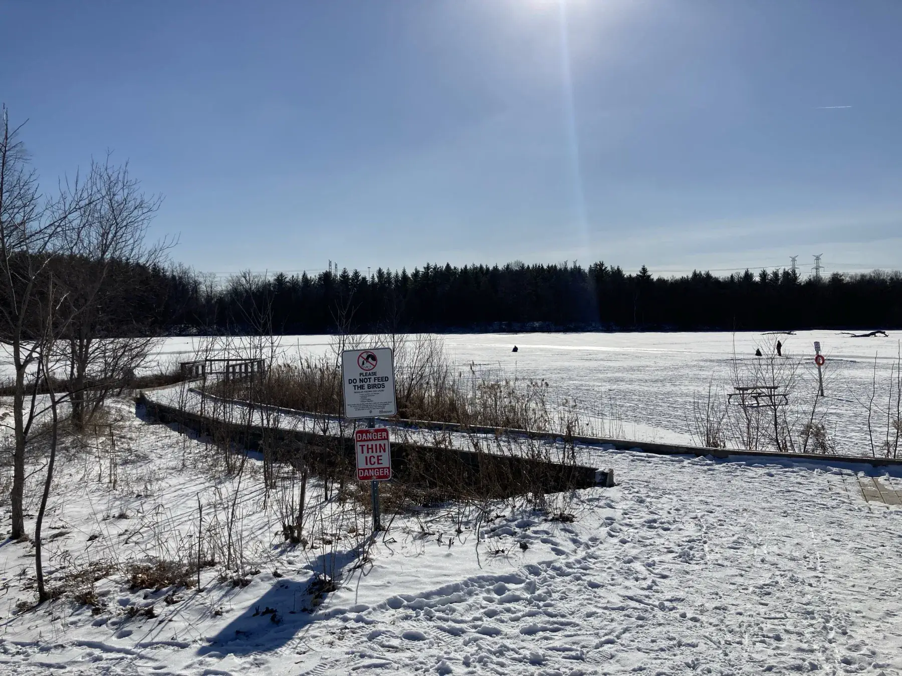 Thin ice warning sign and frozen lake at Milne Dam Conservation Park
