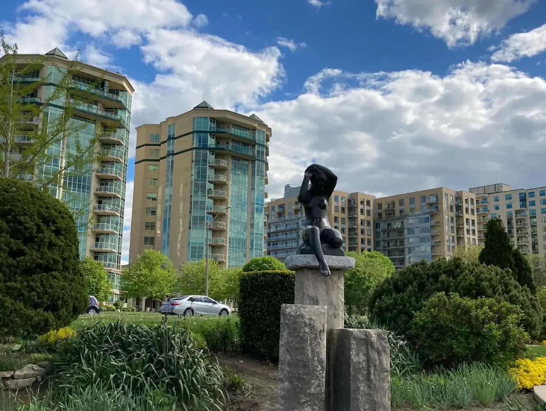 Public sculpture and planted gardens beside Windsor riverfront condos
