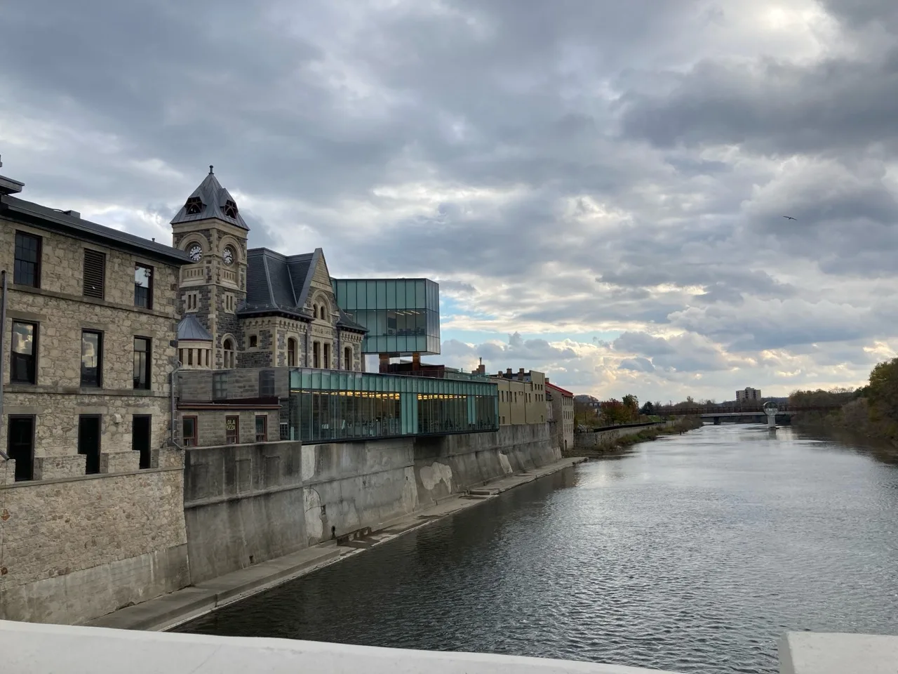 Historic Cambridge Galt architecture beside the Grand River under dramatic clouds