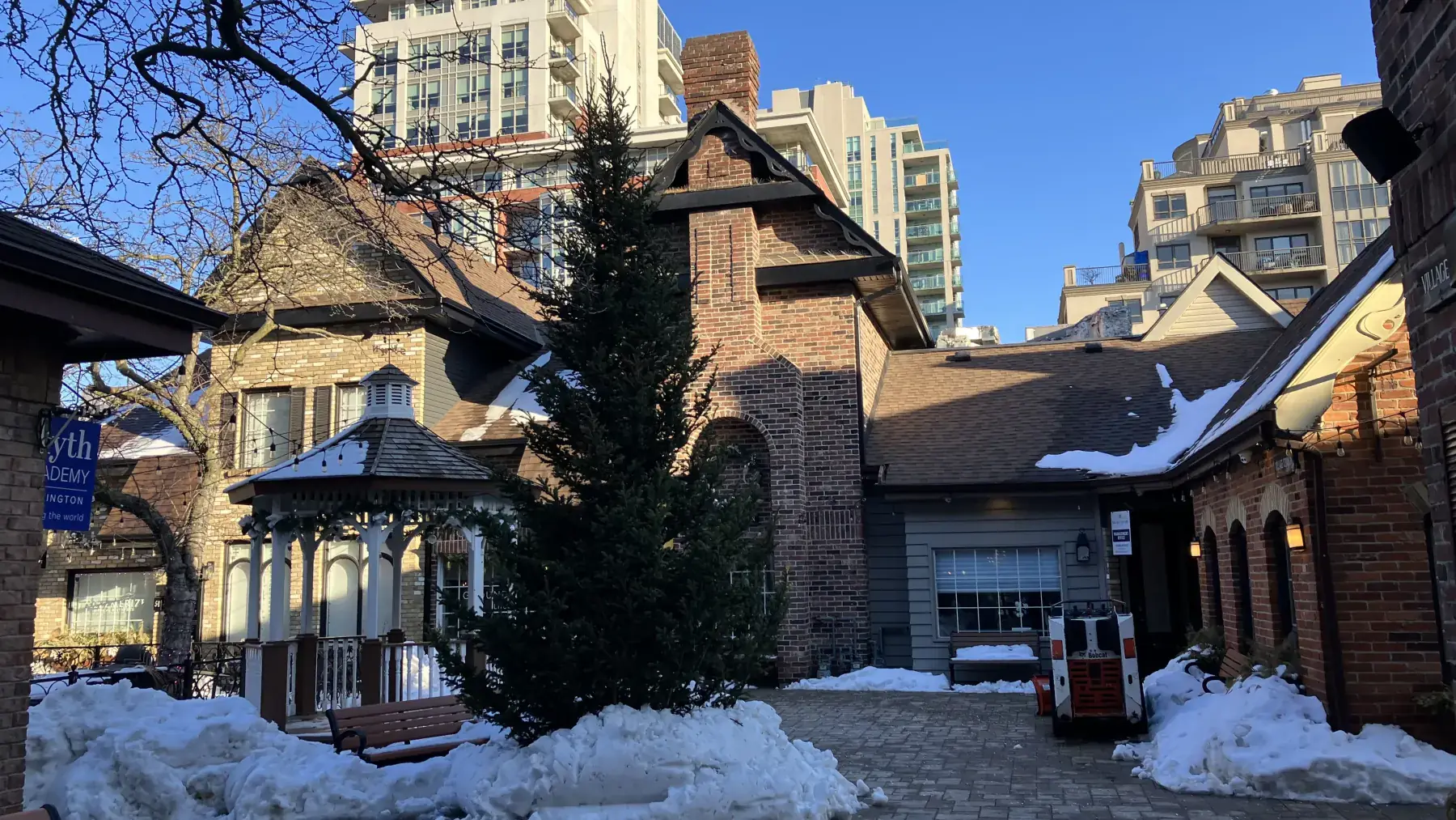 Pátio da Burlington Village Square com edifícios de tijolos e neve