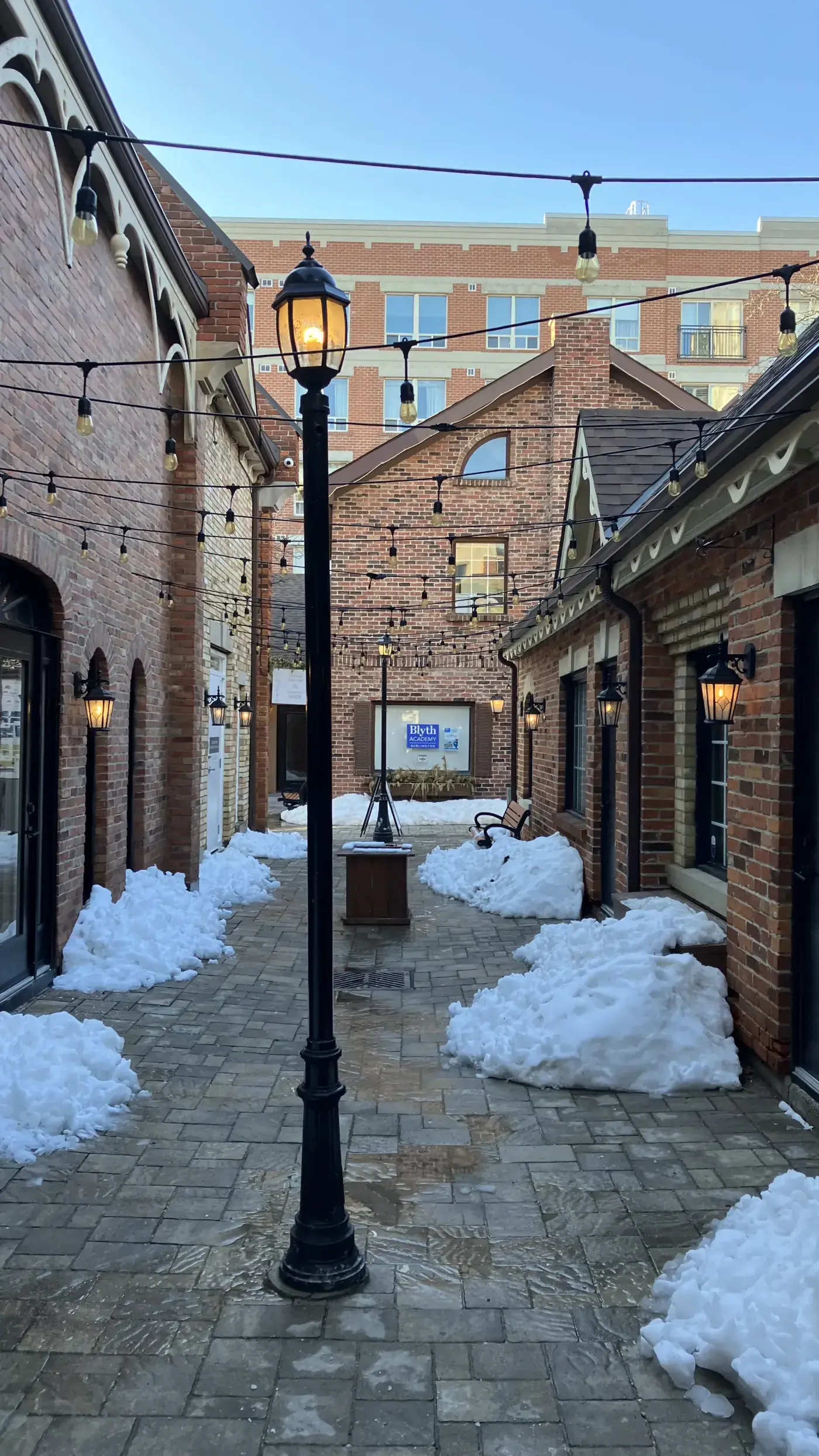 Lanterna da Burlington Village Square e passarela de tijolos nevados