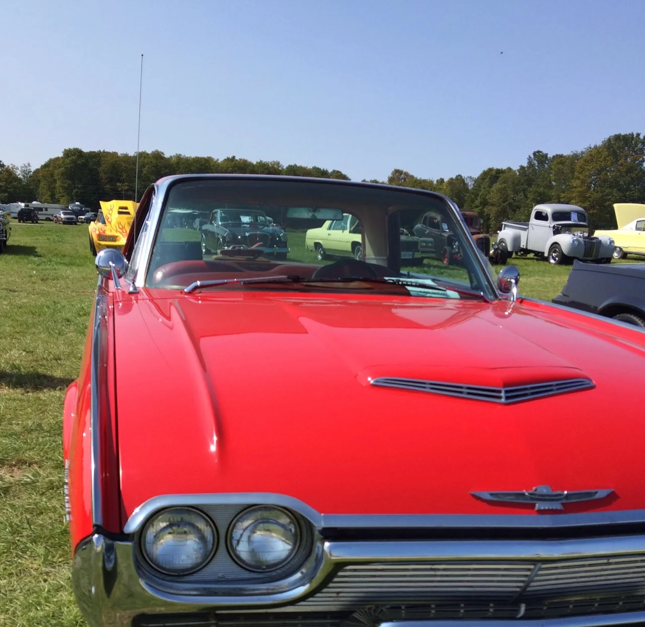 Red vintage car on grass at an Oro-Medonte classic car show near Barrie