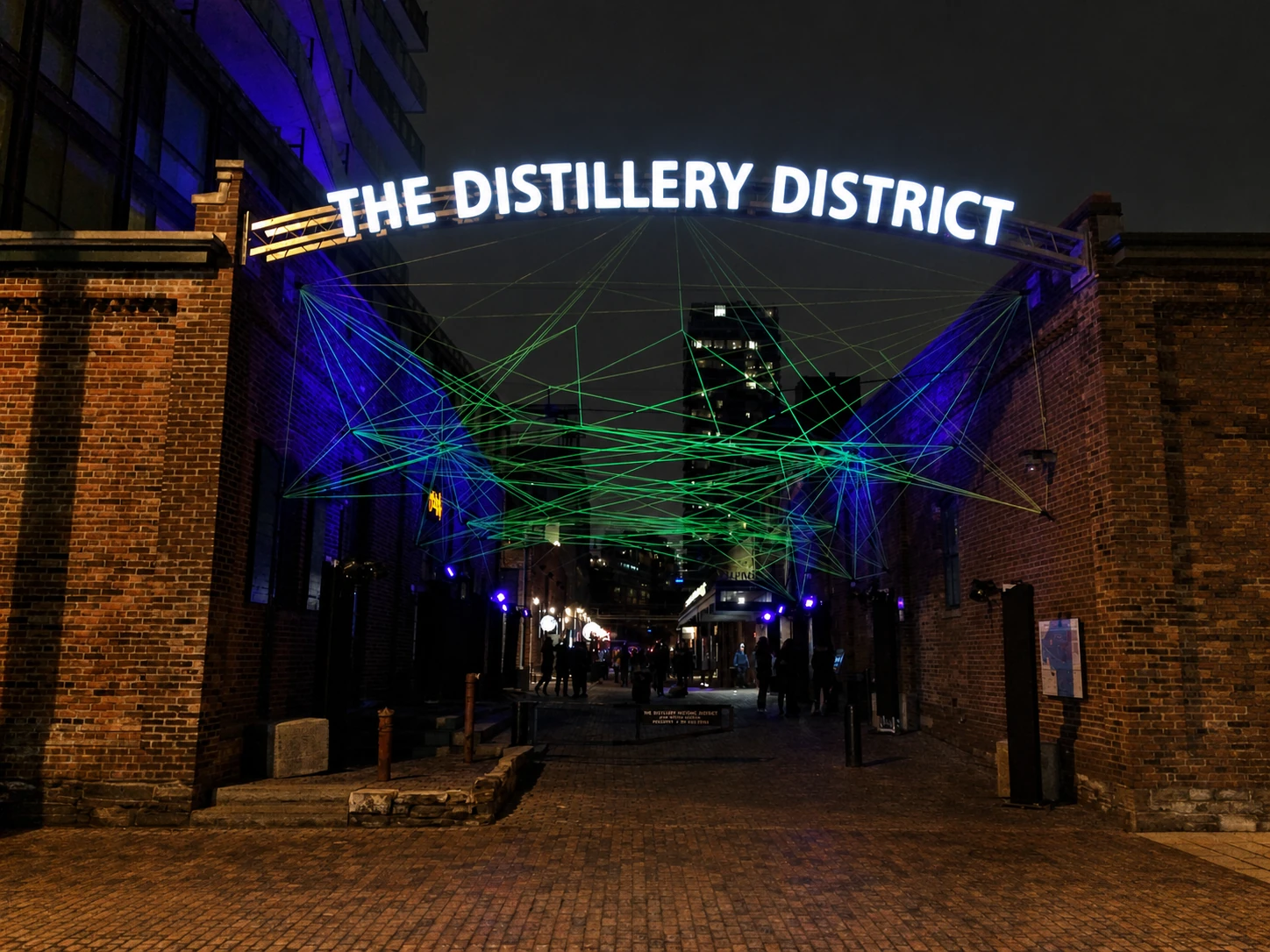 Illuminated Distillery District entrance at night in Toronto