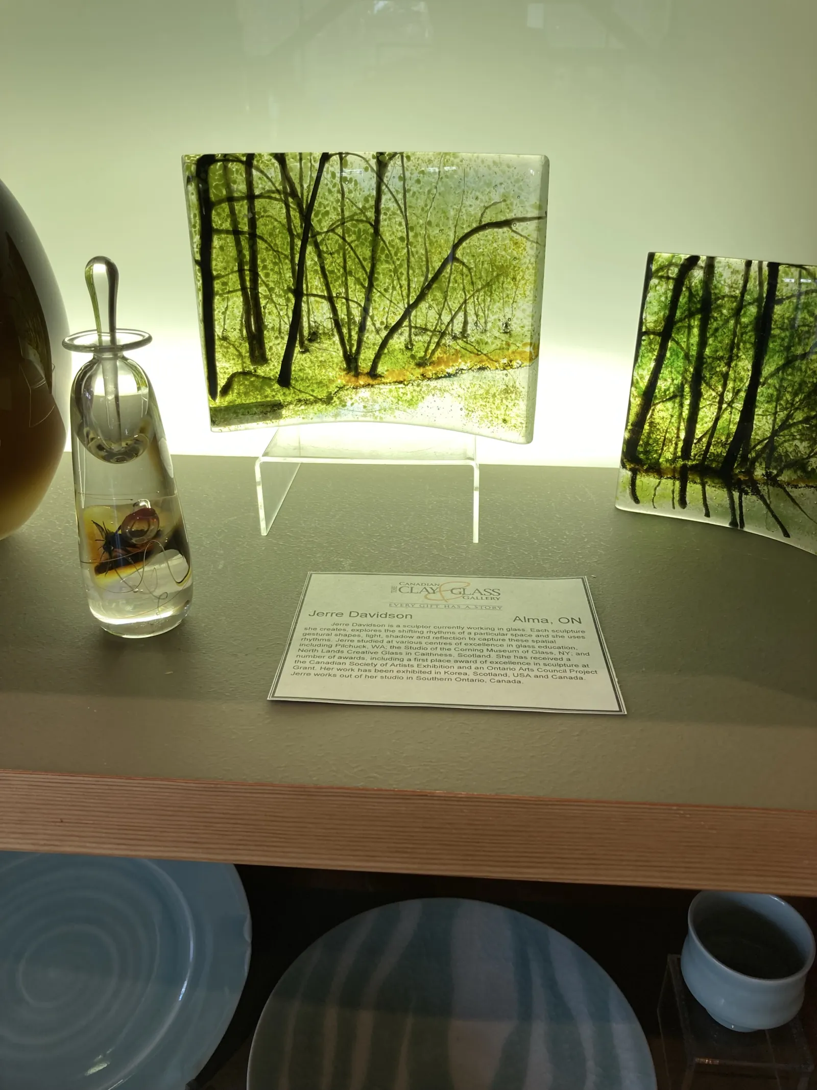 Green forest-themed glass artwork at the Canadian Clay and Glass Gallery in Waterloo