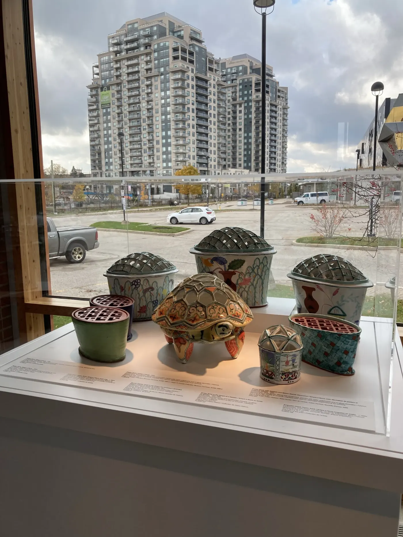 Canadian Clay and Glass Gallery display in Waterloo with ceramic pieces and condos outside the window