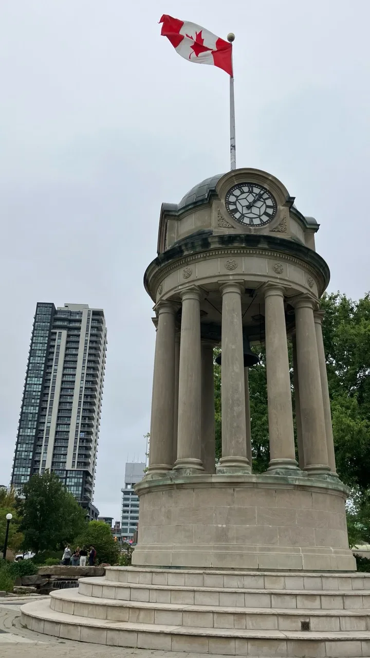 Old Kitchener City Hall clock tower in Victoria Park with modern condos behind it