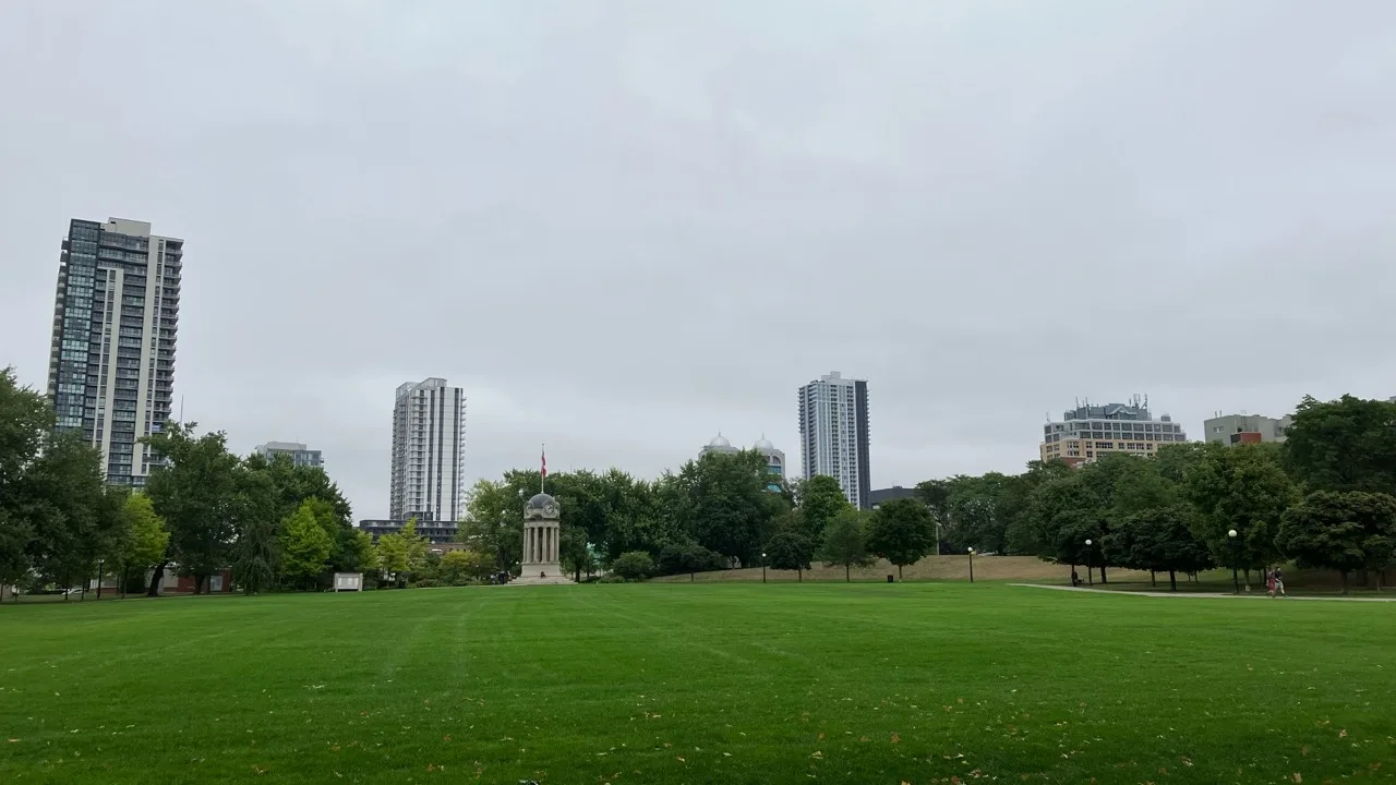 Victoria Park in Kitchener with green lawn and downtown high-rise skyline