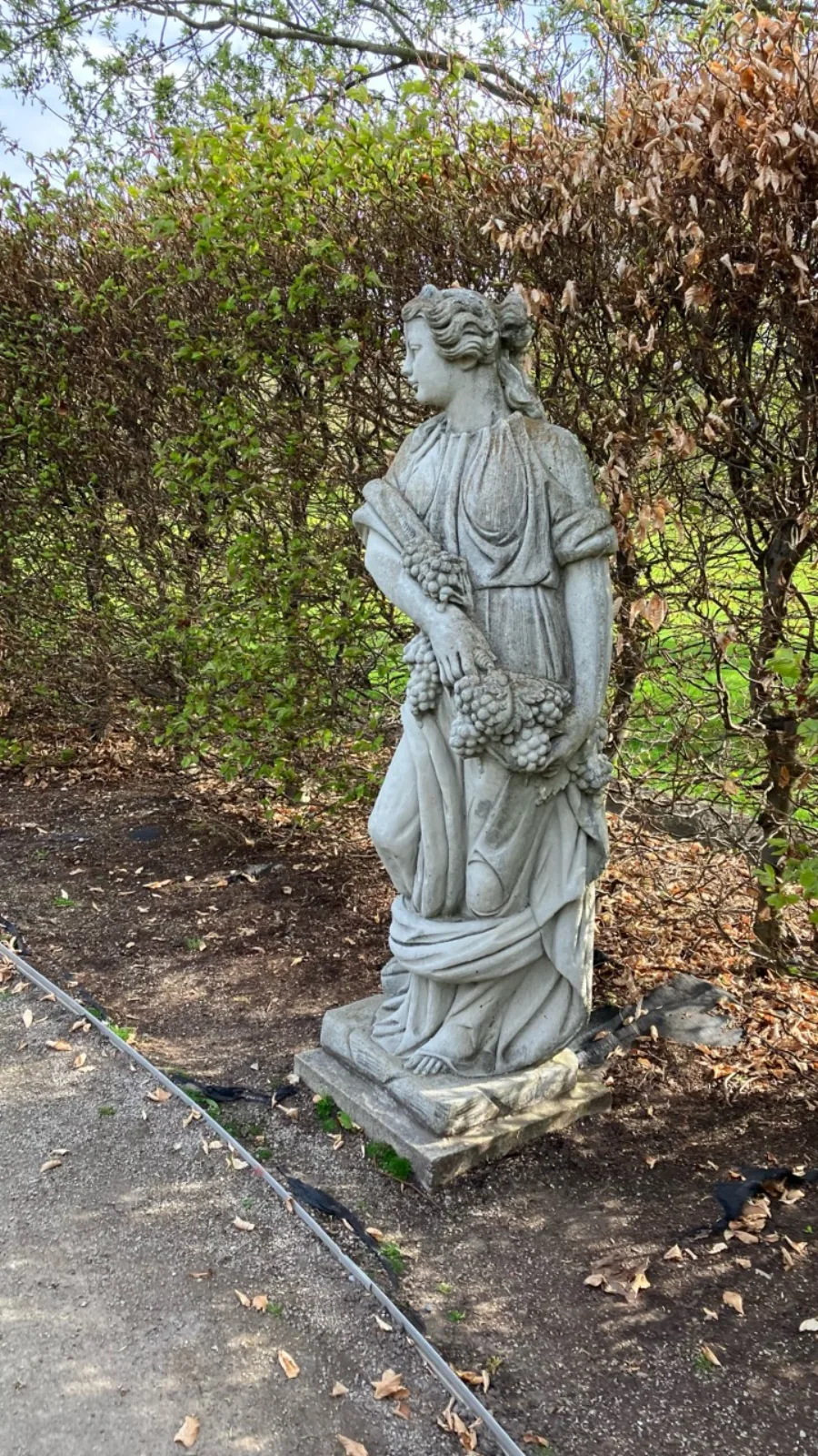 Classical garden statue holding fruit at the University of Guelph Arboretum