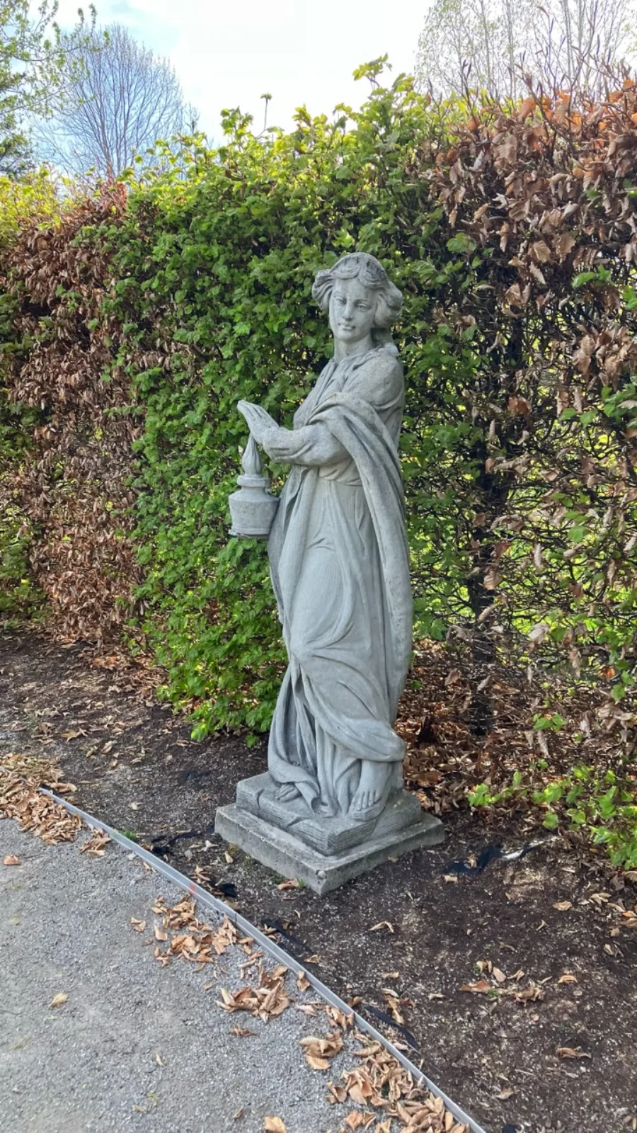 Classical garden statue holding a brazier at the University of Guelph Arboretum