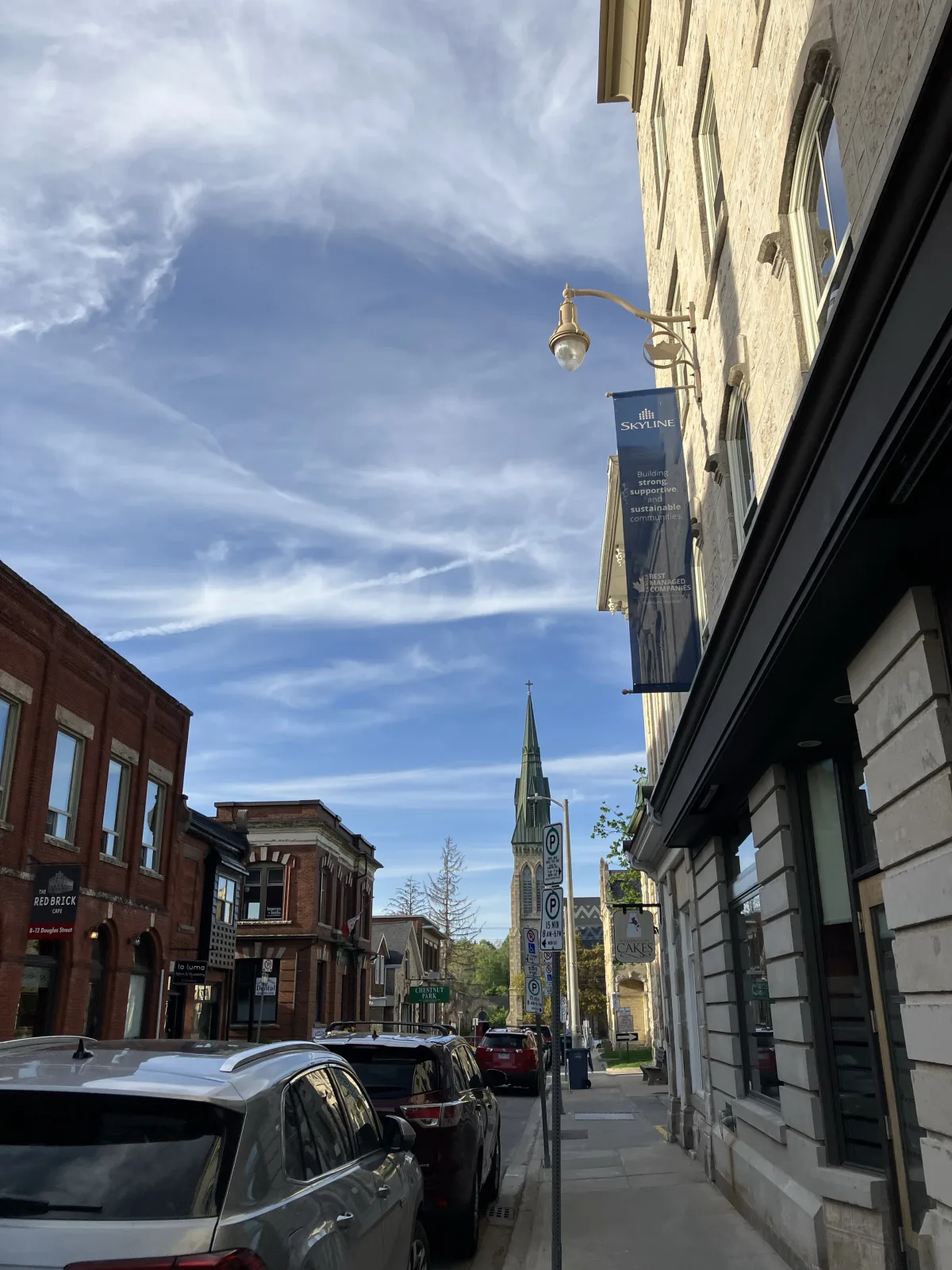 Downtown Guelph street with historic stone buildings and a church spire