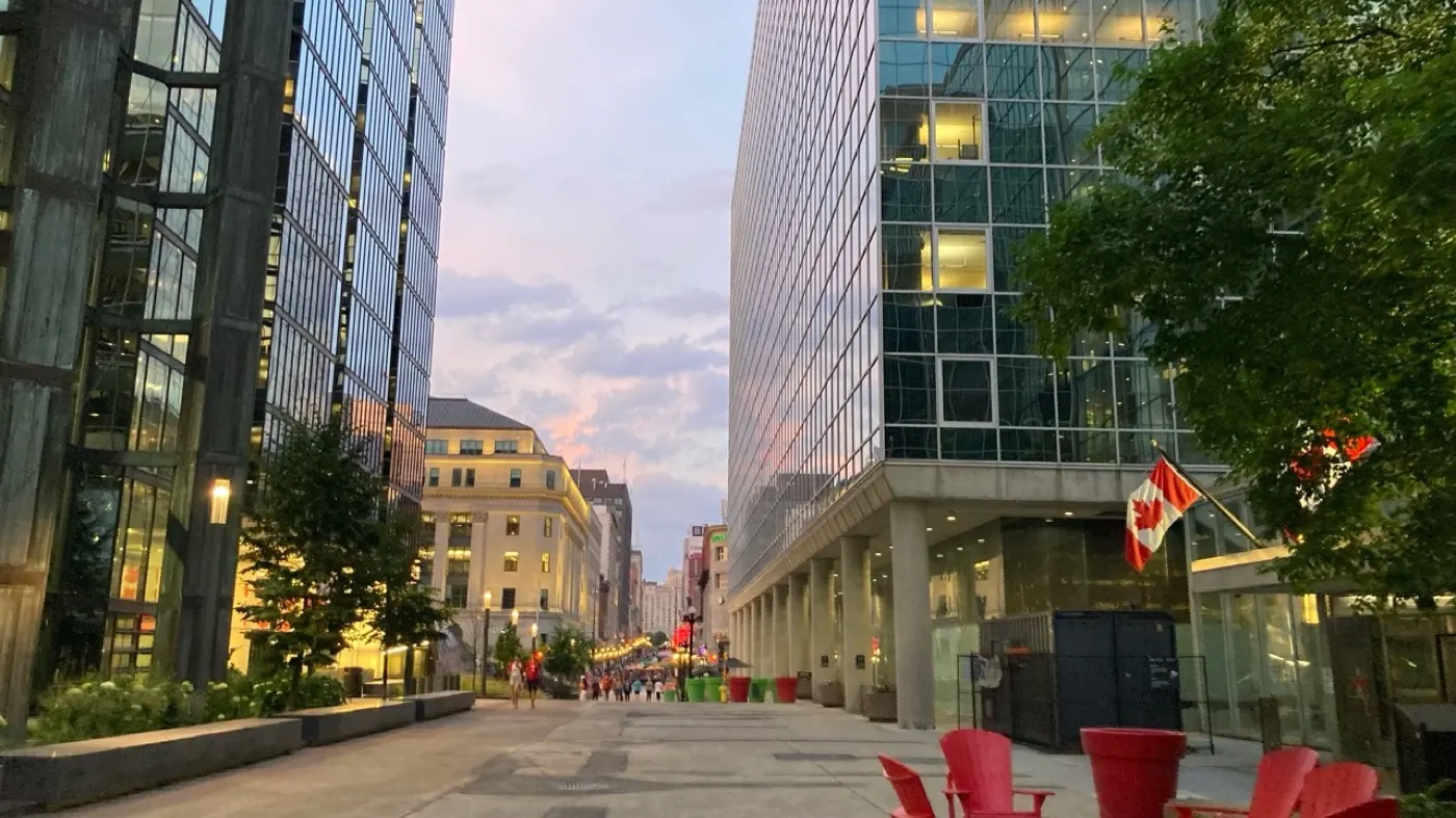 Downtown Ottawa pedestrian street at dusk with Canadian flags and restaurants nearby