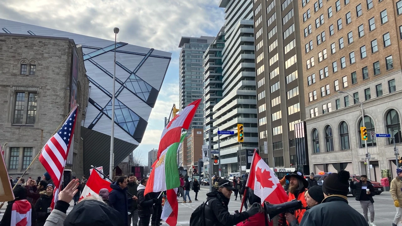 Demonstrators with Canadian and other flags near the Royal Ontario Museum and Queen's Park