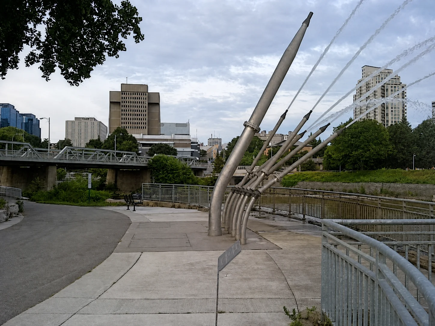 Fountain sculpture beside the Thames River with downtown London Ontario skyline